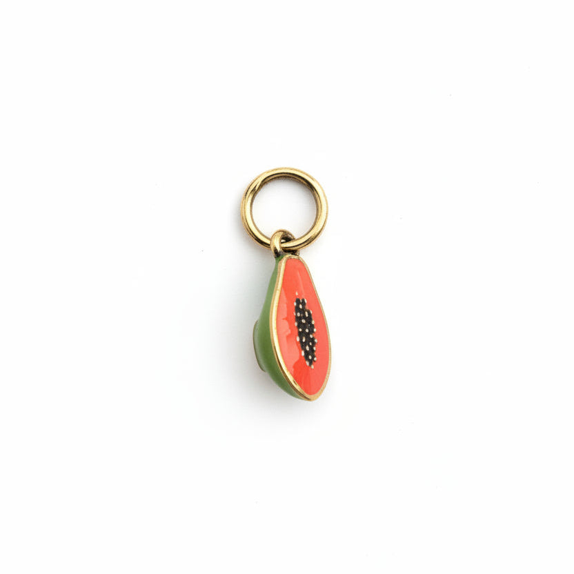 Half Papaya-shaped keychain charm on a textured fabric background